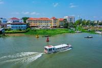 a boat traveling down a river in a city at Victoria Chau Doc Hotel in Chau Doc