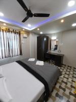 a bedroom with a large bed with a ceiling fan at Le Luminous, Home Stay in Port Blair