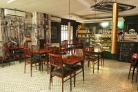 een restaurant met houten tafels en stoelen in een kamer bij Heritage Luxury Suites All Suite Hotel in Lahore