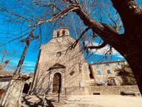 an old stone church with a tower with a cross at Le Planzollais in Planzolles