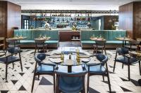 un ristorante con tavoli e sedie e un bar di Prague Marriott Hotel a Praga