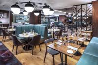 un ristorante con cabine blu, tavoli e sedie di Prague Marriott Hotel a Praga