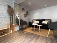 a living room with a black couch and a table at La Petite Rochambelle (hyper centre-ville) in Vendôme