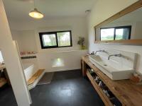 a bathroom with a tub and a sink at Chambres privées dans fermette rénovée proche du Mans au calme in Changé