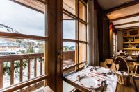 a dining room with a table and a window at Les Monts Charvin in Courchevel