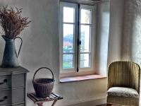 a room with a vase and a chair and a window at Maison Marie in Lagarde
