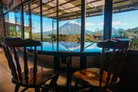 a table with two chairs and a view of a mountain at Chateau Arenal Hotel & Restaurante in El Castillo de La Fortuna