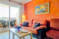a living room with an orange couch and a table at Apartamentos Sanlúcar &amp; Doñana in Sanlúcar de Barrameda