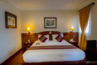 a bedroom with a large bed and two lamps at Victoria Chau Doc Hotel in Chau Doc