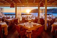un restaurante con mesas y vistas al océano en Roccobarocco Boutique Hotel, en Isquia