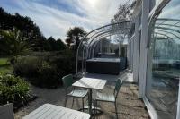 a patio with a table and chairs and a greenhouse at Hôtel Arcadia in Lannion