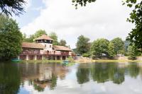 ein großes Gebäude am Wasser mit einem See in der Unterkunft Europe tents camping Domaine des Messires in Herpelmont