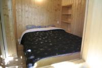 a bed in a room with a wooden wall at Meublé en Drôme Provençale in Saint-Auban-sur-Ouvèze