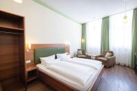 a bedroom with a large white bed and two chairs at Altstadthof Freinsheim in Freinsheim