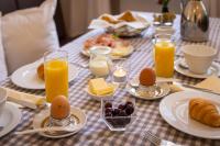 a table with breakfast foods and orange juice and eggs at Altstadthof Freinsheim in Freinsheim