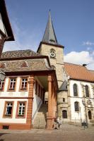 an old building with a clock tower and a church at Altstadthof Freinsheim in Freinsheim