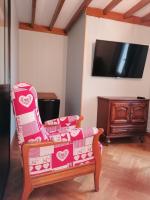ein Wohnzimmer mit einem Stuhl und einem TV in der Unterkunft La longére fleurie in Cucq