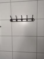 a black shelf on a white tiled wall at Condomínio Residencial Mar Azul in Imbituba