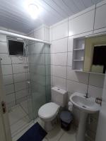 a bathroom with a toilet and a sink and a shower at Condomínio Residencial Mar Azul in Imbituba