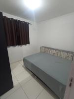 a bedroom with a bed in a room with a window at Condomínio Residencial Mar Azul in Imbituba