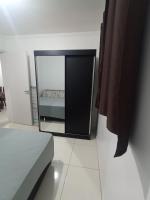 a mirror in a room with a bed in it at Condomínio Residencial Mar Azul in Imbituba
