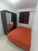 a bedroom with a bed and a mirror at Condomínio Residencial Mar Azul in Imbituba