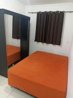 a bedroom with a bed and a mirror at Condomínio Residencial Mar Azul in Imbituba