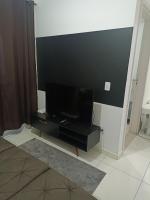 a living room with a flat screen tv on a wall at Condomínio Residencial Mar Azul in Imbituba