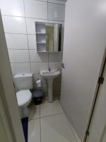a small bathroom with a toilet and a sink at Condomínio Residencial Mar Azul in Imbituba