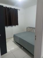a bedroom with a bed and a black curtain at Condomínio Residencial Mar Azul in Imbituba