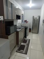 a kitchen with a sink and a refrigerator at Condomínio Residencial Mar Azul in Imbituba