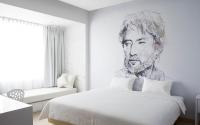 a bedroom with a drawing of a man on the wall at Beat Hotel Bangkok in Bangkok