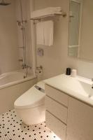 a white bathroom with a toilet and a sink at Capital Hotel SongShan in Taipei