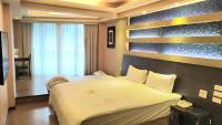 ein Hotelzimmer mit einem großen Bett mit Telefon darauf in der Unterkunft Bitan Hotel in Xindian