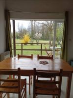a dining room table with chairs and a large window at CAMPING DE LA CHALARONNE in Saint-Didier-sur-Chalaronne