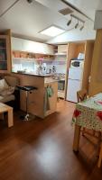 a kitchen and living room with a table and a counter at Mobil home 6 personnes Forêt des landes in Mimizan