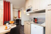 a kitchen with a table with a bowl of oranges on it at Villa Serafina Apartements in Nice