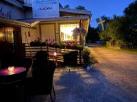Un restaurante con mesas y sillas frente a un edificio. en Stor lägenhet ovanpå café ute på landet, en Hökerum