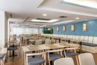 uma sala de jantar com mesas e cadeiras de madeira em Hotel Costa Málaga - Adults Recommended - by Pierre & Vacances em Torremolinos
