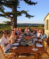 un groupe de personnes assises autour d'une table en bois dans l'établissement The Old Presbytery, à Saint-André-et-Appelles
