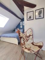 a bedroom with a bed and a chair in it at Equidia Compiègne Free Parking Wifi Self Check-in in Venette