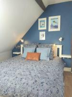 a bedroom with a large bed with blue walls at Equidia Compiègne Free Parking Wifi Self Check-in in Venette