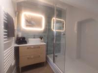 a bathroom with a shower and a sink with lights at Equidia Compiègne Free Parking Wifi Self Check-in in Venette