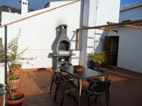 a patio with a table and an outdoor oven at Casa Las Lomas in Prado del Rey