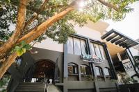 um prédio com uma árvore na frente em MelSol Hotel em Bantay