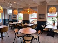 Un restaurante con mesas, sillas y luces. en Hotel Restaurant Toxopeus, en Anjum