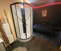 a room with a glass shower with a bed in it at Chambres d’hôte au Chapeau Claque Cabaret in Gueugnon