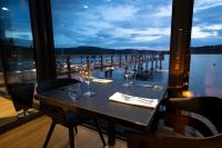 a table with wine glasses and a view of the water at MOLO LIPNO RESIDENCE in Lipno nad Vltavou