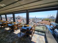 a restaurant with tables and chairs and large windows at Anthemis Hotel in Istanbul