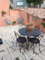 a table and chairs with a vase on a patio at Aux Berges du Canal in Capestang